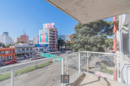 Edificio de viviendas de 1 y 2 dormitorios con patio verde.